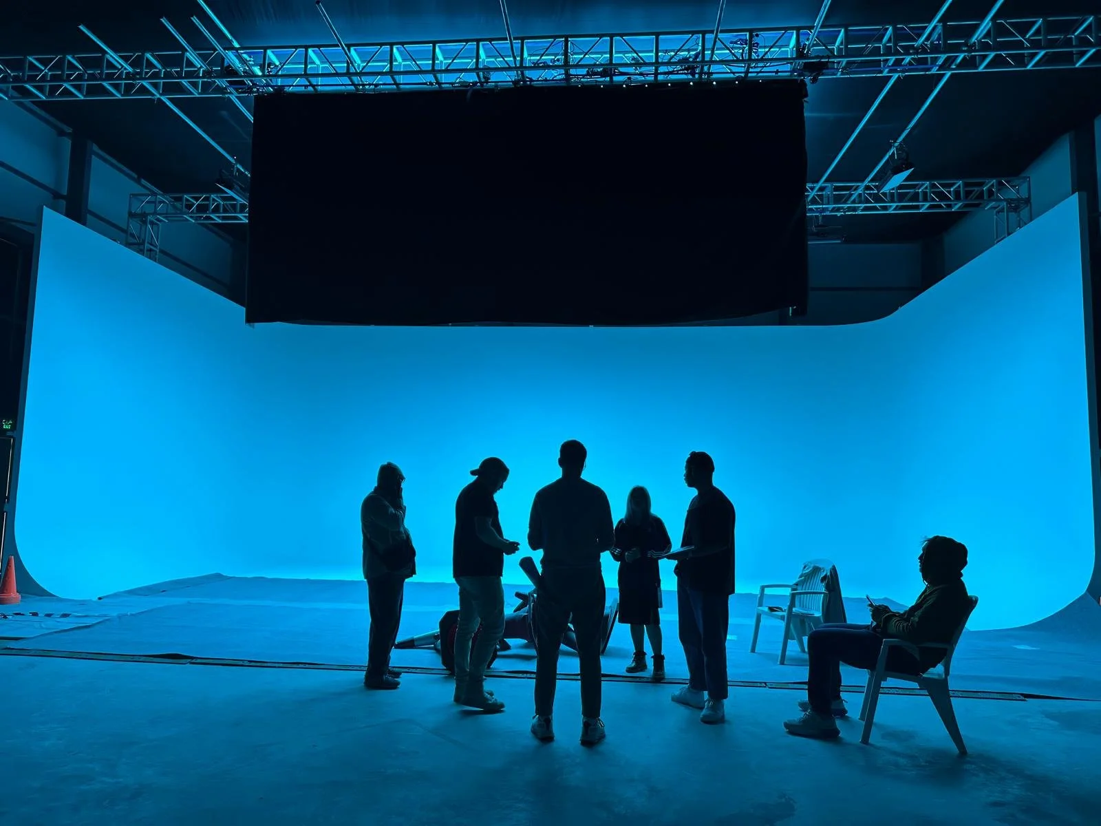 Production team silhouetted against the Tashkila cyclorama illuminated in blue