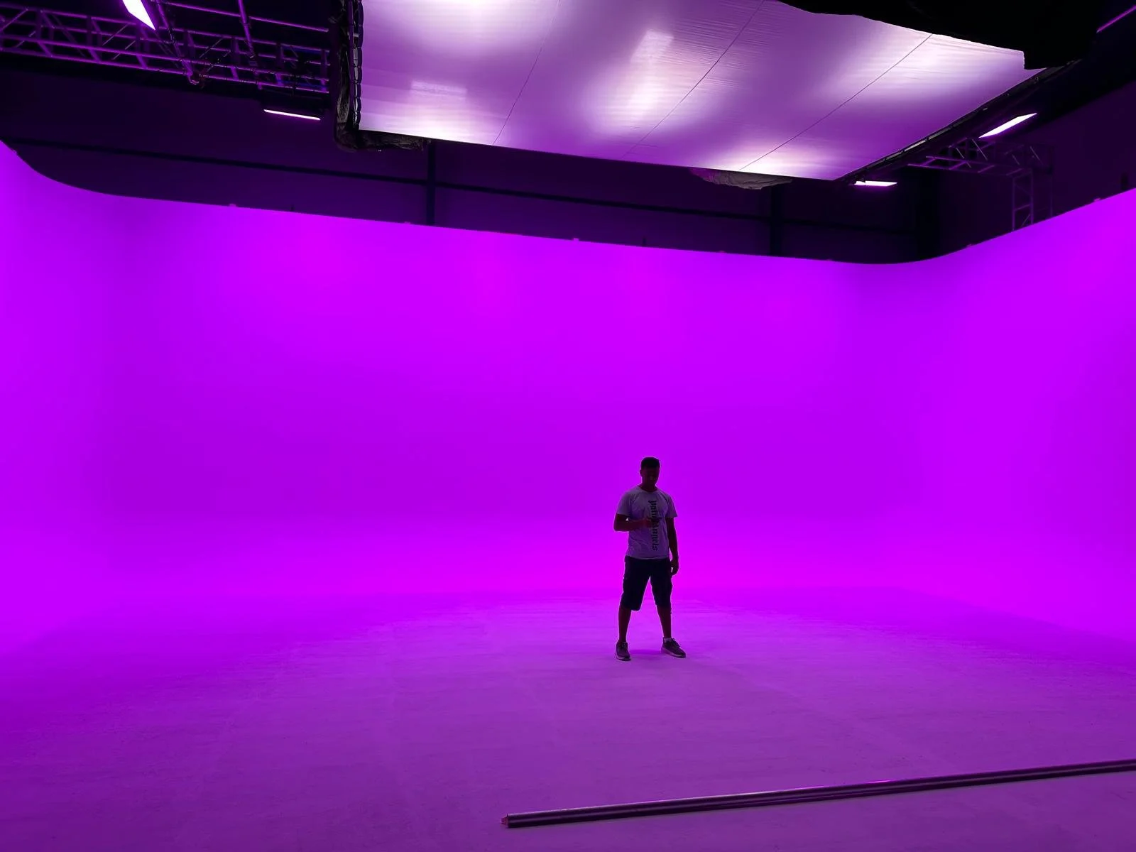 Tashkila cyclorama illuminated in violet with a person standing at its centre for scale