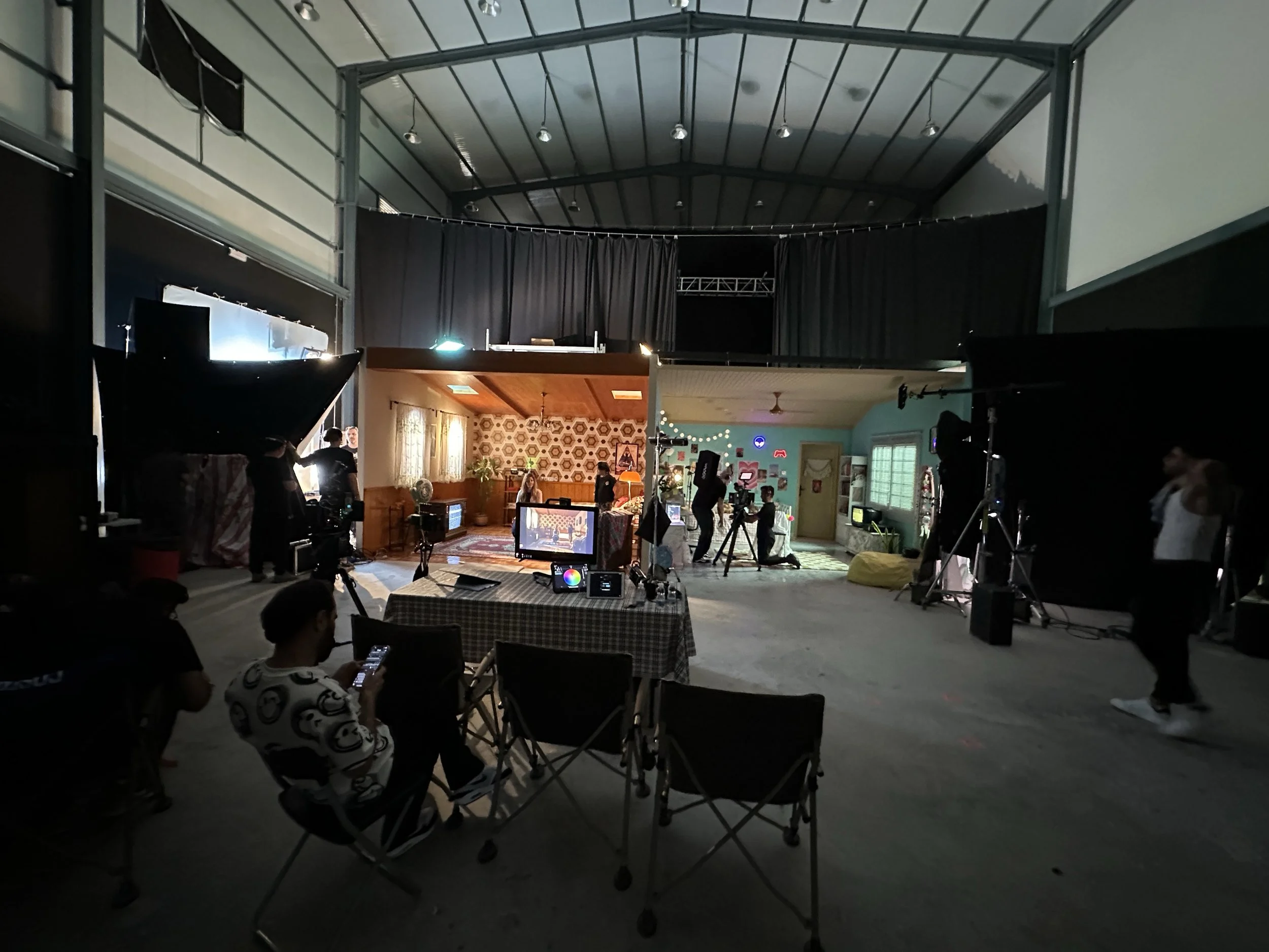 Film crew working around two constructed interior sets inside Tashkila Studio